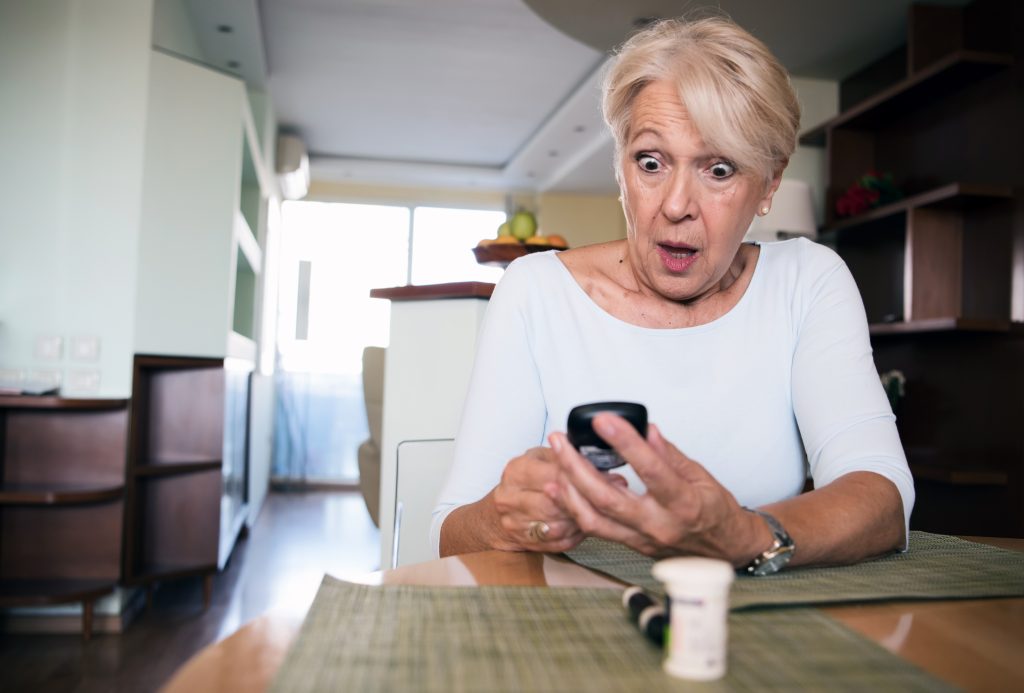 Senior woman with glucometer checking blood sugar